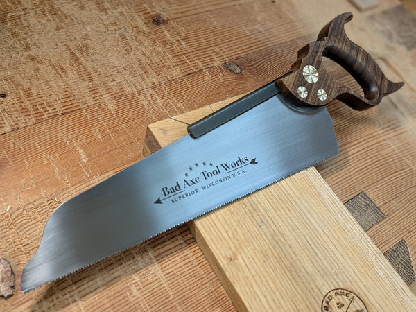a 14 inch half back saw with a walnut handle made by bad axe tool works