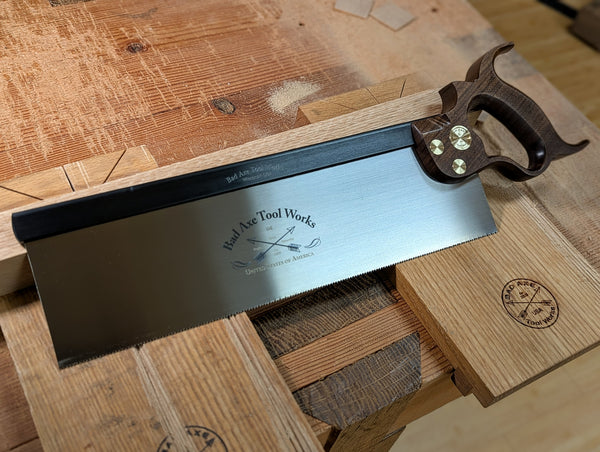 a 14 inch sash saw with a walnut handle and black back with brass fasteners